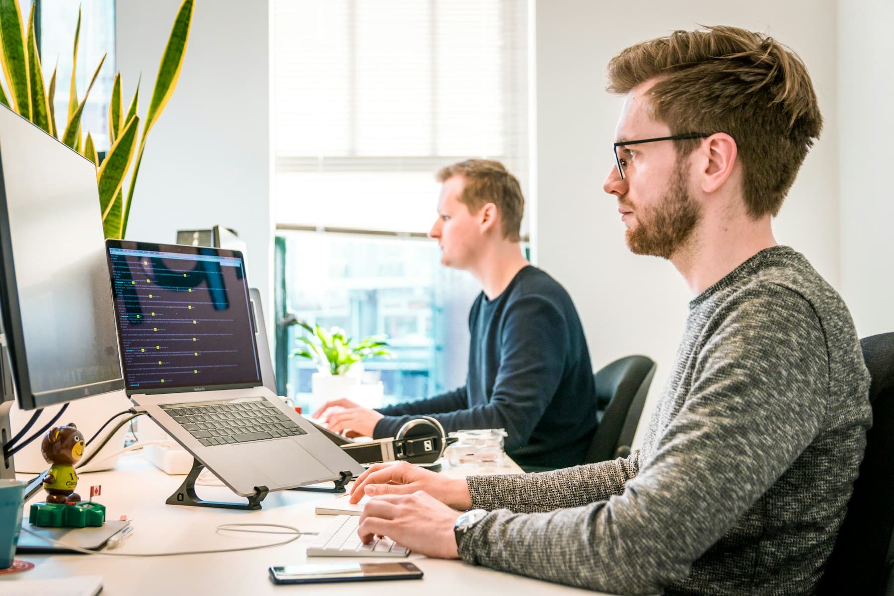 A team working together around a laptop in a bright office